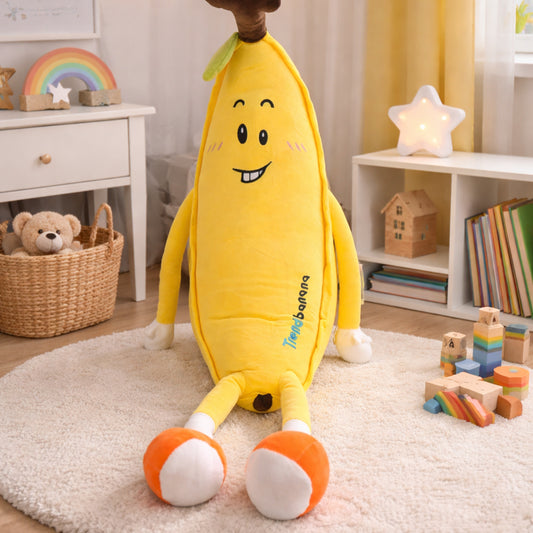 Peluche de plátano amarillo con cara sonriente y pies naranjas, suave